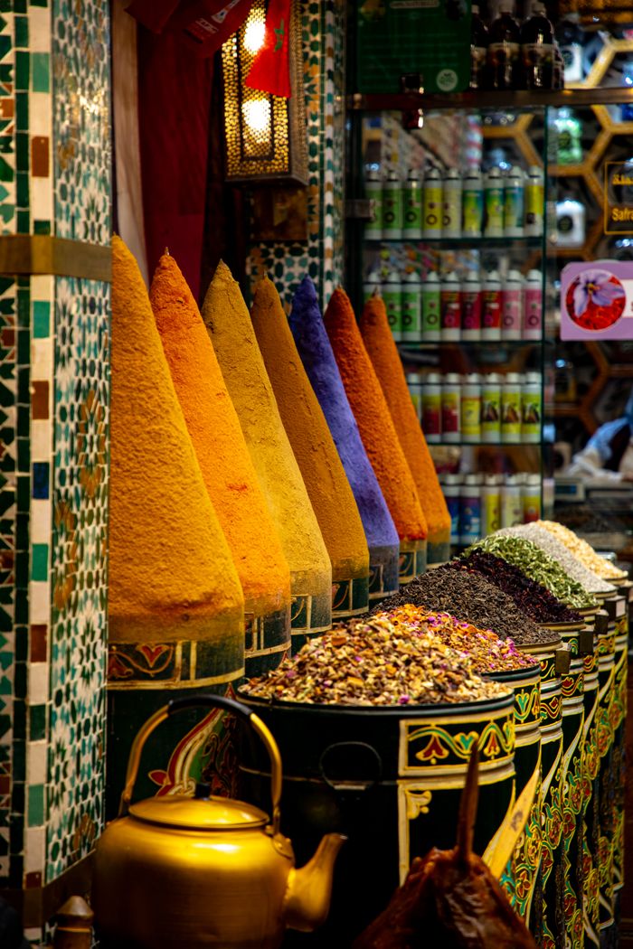 Colorful spices displayed at a bustling Marrakesh market in Morocco.